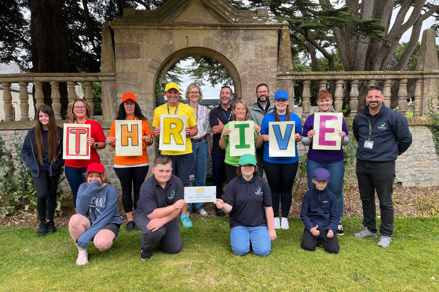 Staff and pupils at Dovecote School receiving their Thrive School of Excellence award